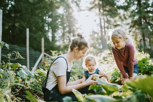 a mother and two children in a vegetable garden